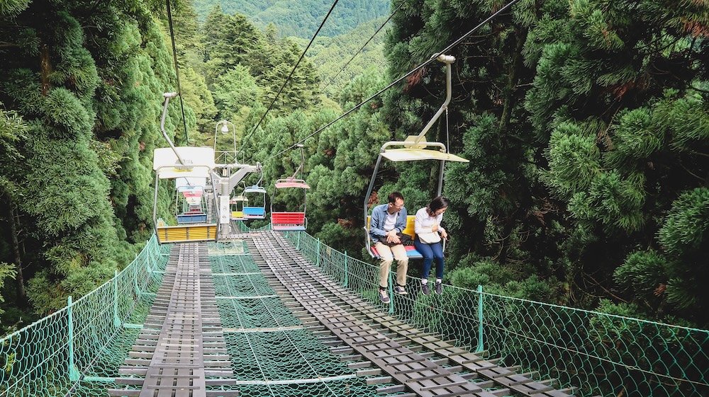 Chair lift with passengers heading up to Mount Takao, Japan 