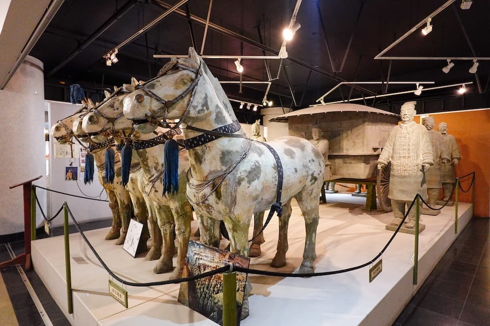 Replica terracotta warriors and horse-drawn chariot figures on display inside the Chinese Cultural Centre museum in Calgary, Alberta, Canada.