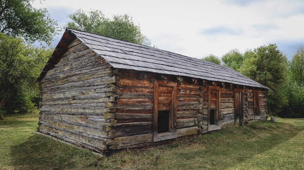 Butch Cassidy ranch cabin in Cholila Patagonia Argentina historic site Historic log cabin of Butch Cassidy ranch in Cholila Patagonia Argentina surrounded by trees and grass, representing frontier history and outlaw legends in the region