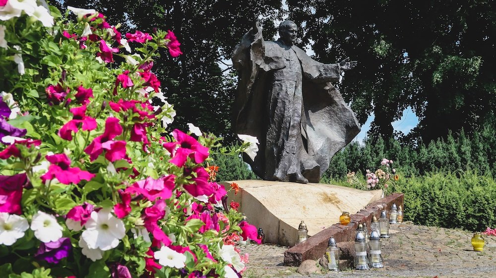 Colorful flowers and religious statue on Cathedral Island (Ostrów Tumski) in Poland