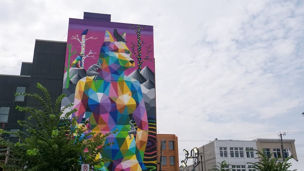 Colourful geometric animal mural on a building in Old Strathcona, Edmonton, Alberta, Canada Large multicoloured geometric animal mural covering the side of a building in Old Strathcona, with trees, neighbouring brick façades and a cloudy sky in Edmonton, Alberta, Canada.