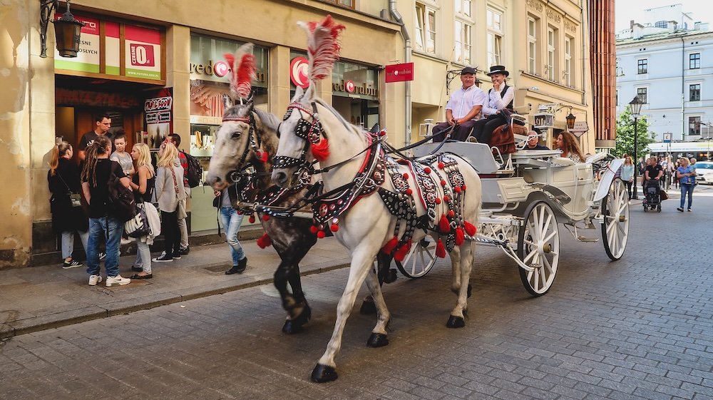 Colorful horse and carriage ride along the Royal Road or Royal Route Droga Królewska in Krakow, Poland 