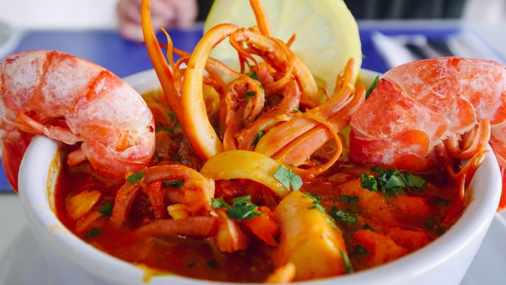 Patagonian seafood stew with shrimp, squid, and shellfish in a rich tomato broth served in Comodoro Rivadavia, Chubut, Argentina, highlighting hearty coastal cuisine from this industrial Atlantic hub along Route 3.