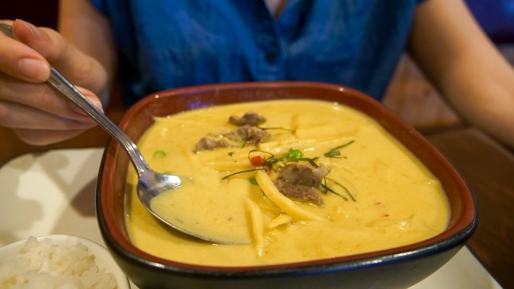 Cranbrook, BC dining scene featuring a rich and creamy spicy curry served at Family Thai Restaurant, highlighting the vibrant yellow broth, tender meat, fresh herbs, and why this local spot is a go-to for flavour-packed comfort food.
