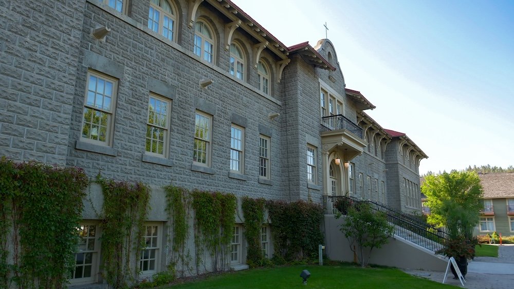 St. Eugene Mission near Cranbrook, British Columbia, showing the historic stone building and landscaped grounds, highlighting a popular day trip stop known for its restored architecture, peaceful setting, and cultural significance in the Kootenays.