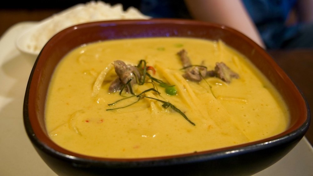Thai Family Restaurant in Cranbrook, British Columbia, serving a super spicy green coconut curry with tender meat and fresh herbs, showing one of the city’s standout dining experiences and a bold, comforting meal after a full summer day of exploring.