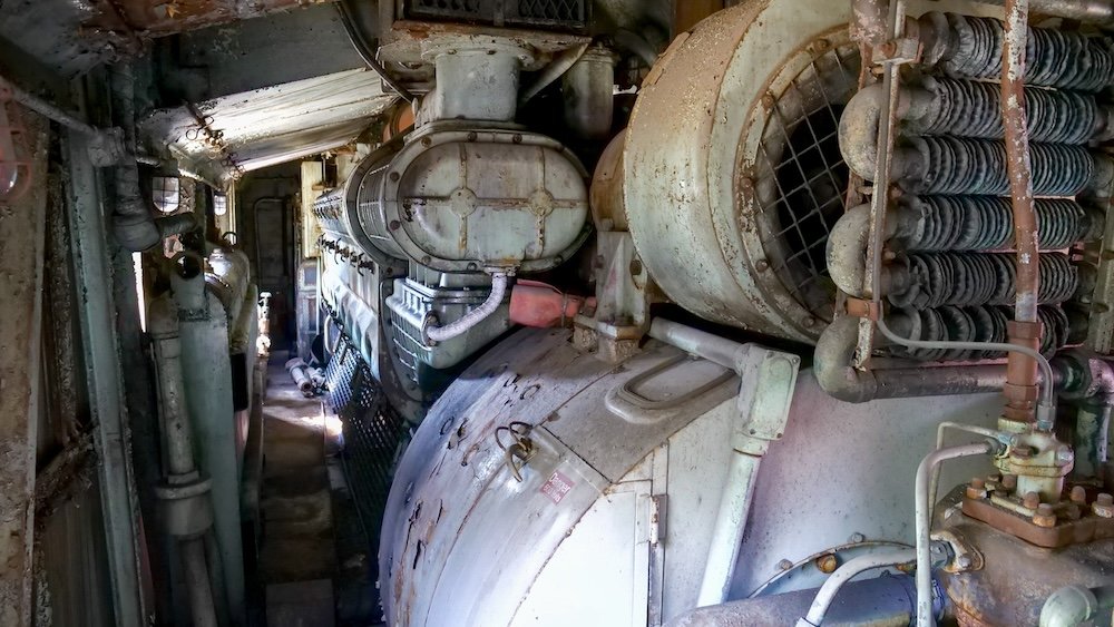 Historic train engine interior on the guided train tour at the Cranbrook History Centre in Cranbrook, British Columbia, showing original mechanical components, pipes, and machinery that reveal how early Canadian railway engines were operated.
