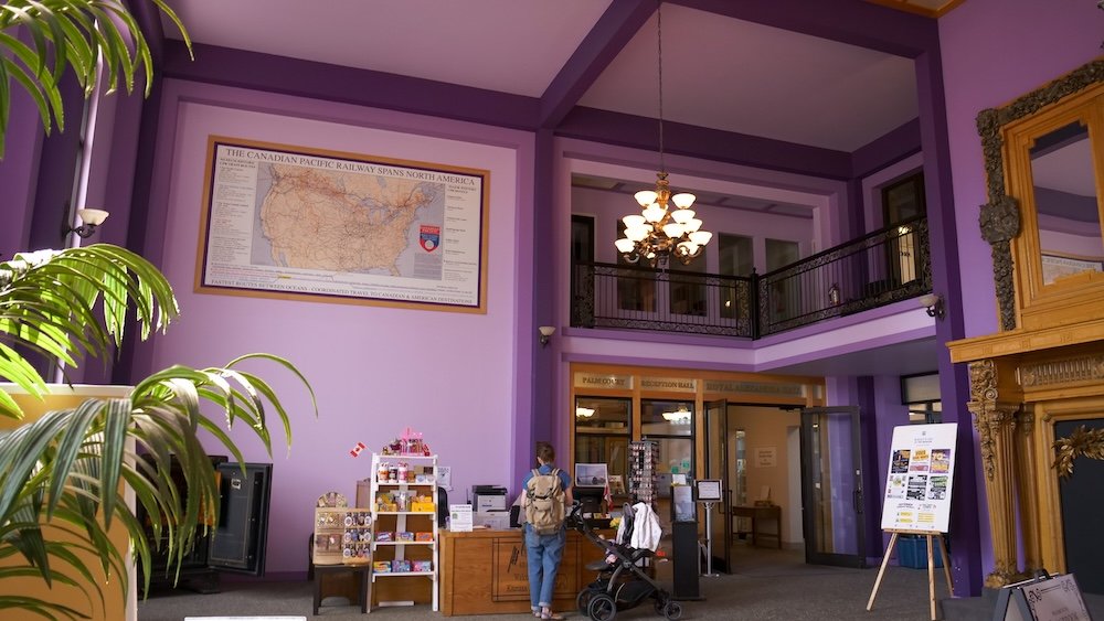 Cranbrook History Centre Interior and Railway Heritage Displays Interior of the Cranbrook History Centre in Cranbrook, British Columbia showing the bright purple walls, historic railway displays, visitor information desk, and upper balcony, highlighting one of the city’s most important cultural attractions for learning about local heritage and rail history.