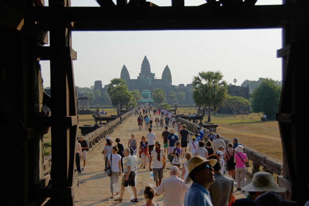 Crowds of tourists flocking towards Angkor Wat through one of the many gates 