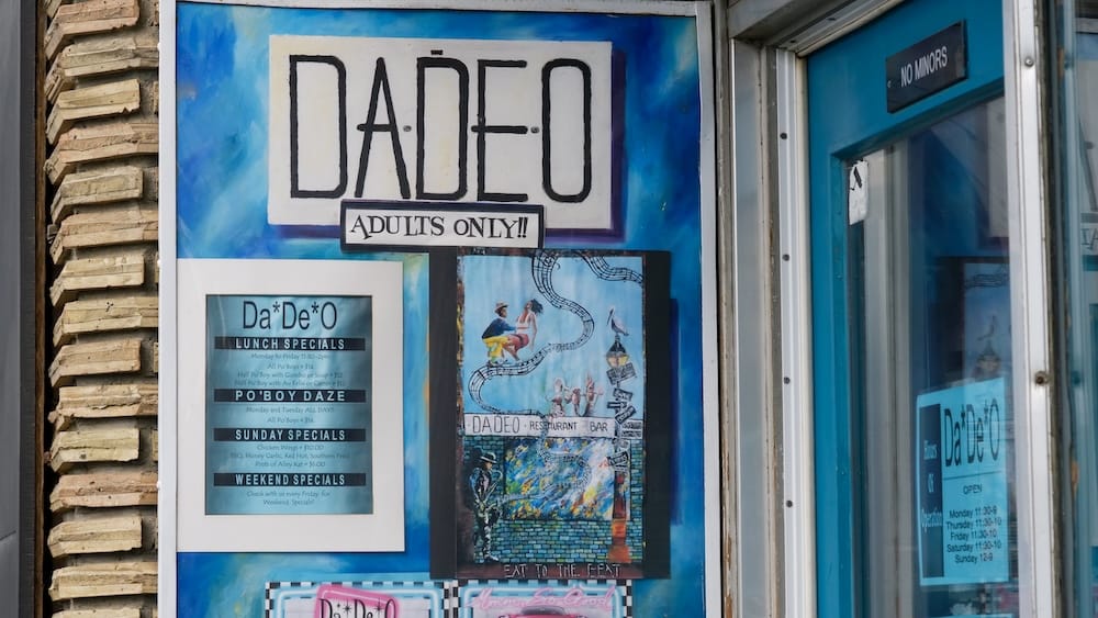 DaDeO Restaurant Entrance and Signage on Whyte Avenue in Edmonton, Alberta, Canada Exterior entrance of DaDeO restaurant on Whyte Avenue in Edmonton, Alberta, Canada, showing its blue-framed doorway, large hand-painted sign, lunch-specials board and adults-only notice.