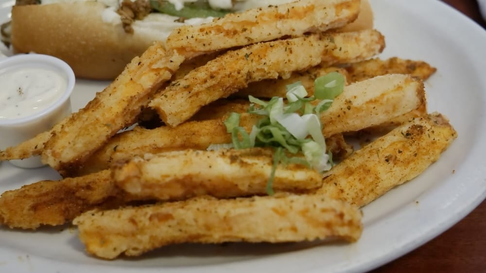DaDeO sweet potato fries on Whyte Avenue in Old Strathcona, Edmonton, Alberta, Canada Seasoned sweet potato fries served at DaDeO on Whyte Avenue in Edmonton, Alberta, Canada, with chopped green onions, a creamy dipping sauce and part of a po’boy visible behind.