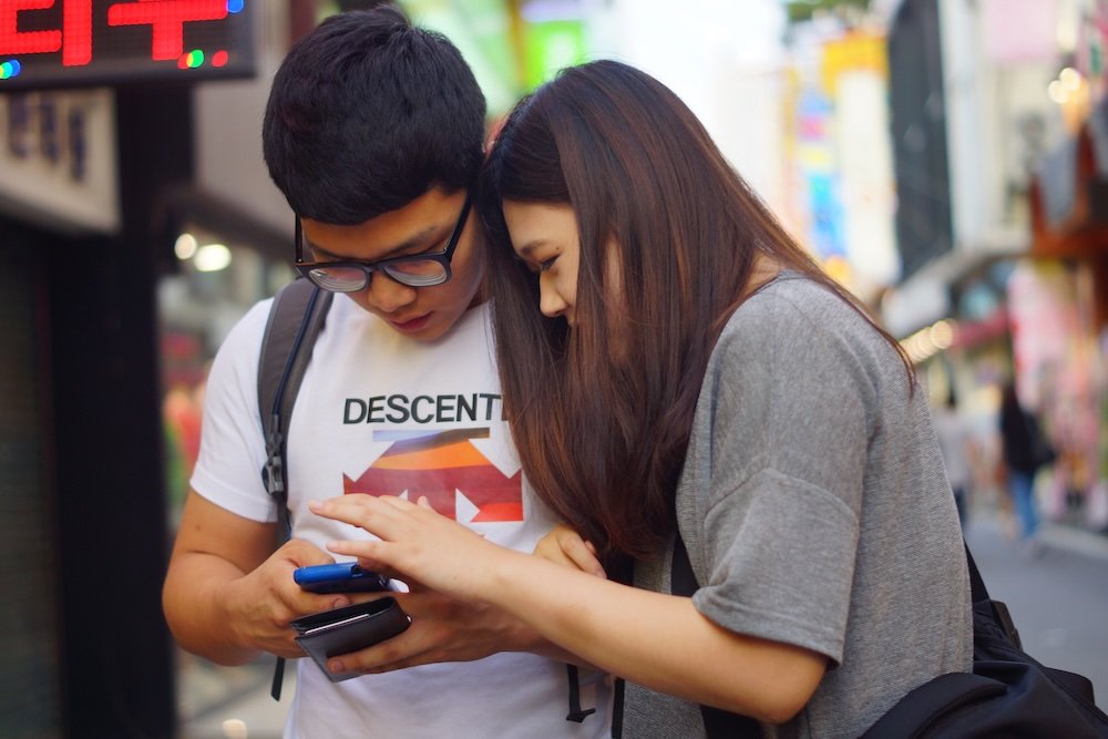 Daejeon street scene couple checking phone 