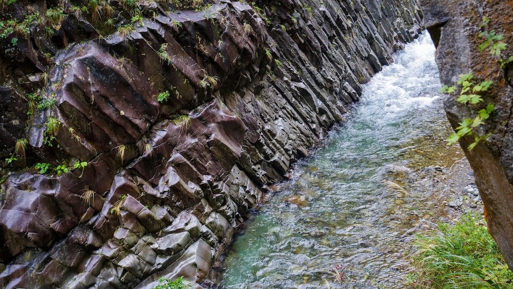 day trip to Kiyotsu Gorge reveals canyon walls adorned with fiery autumn foliage reflected in clear waters below