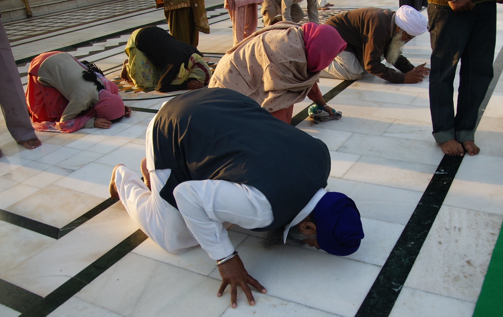 Devotees pay their respect by bowing in servitude at the Golden Temple, India
