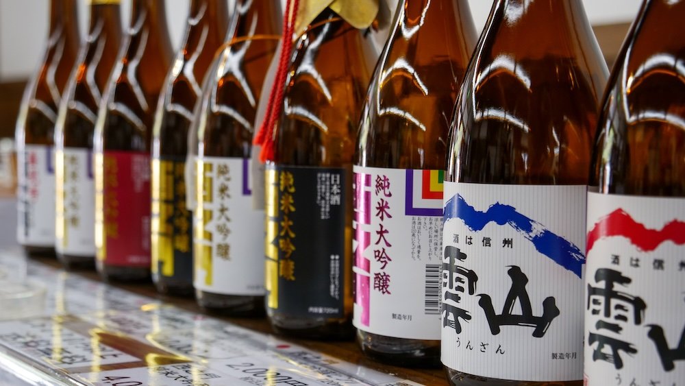 Diverse selection of sake bottles lined up 