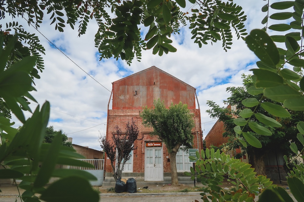 Dolavon historic brick building framed by leafy branches in the Chubut River valley of Welsh Patagonia Argentina highlighting the quiet architecture of this small Welsh settlement along the inland detour from Patagonia’s Atlantic coastal route.