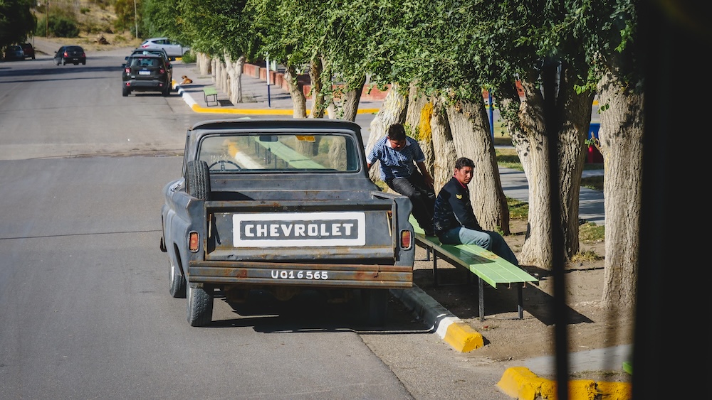 Street scene in Dolavon Welsh Valley town in Patagonia Argentina Dolavon town street scene in the Welsh Valley of Chubut Patagonia Argentina where a vintage Chevrolet pickup and locals resting beneath trees capture everyday life in one of the small communities founded by Welsh settlers.