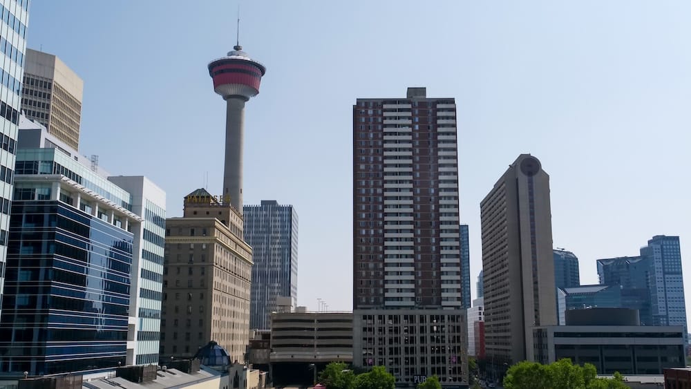 Downtown Calgary Alberta Canada Skyline with Calgary Tower and High-Rise Buildings in the Central City Core Downtown Calgary skyline in Alberta, Canada, with Calgary Tower rising above a cluster of high-rise buildings and offices under a clear summer sky in the central city.