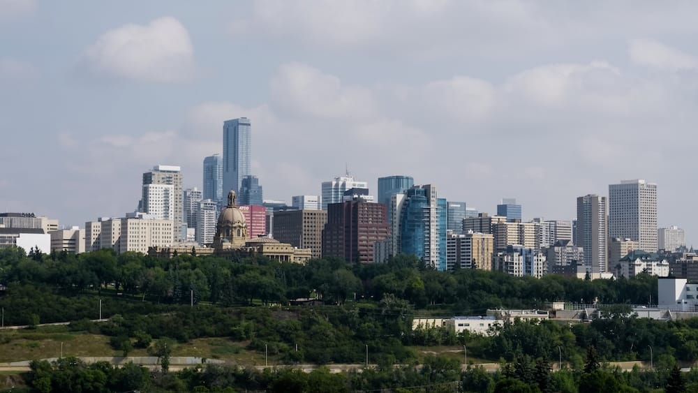 Downtown Edmonton Skyline with Legislature Dome, Alberta, Canada The downtown Edmonton skyline in Alberta, Canada, seen across the North Saskatchewan River valley, with the Alberta Legislature Building's dome visible among the high-rise towers and green tree cover in the foreground.