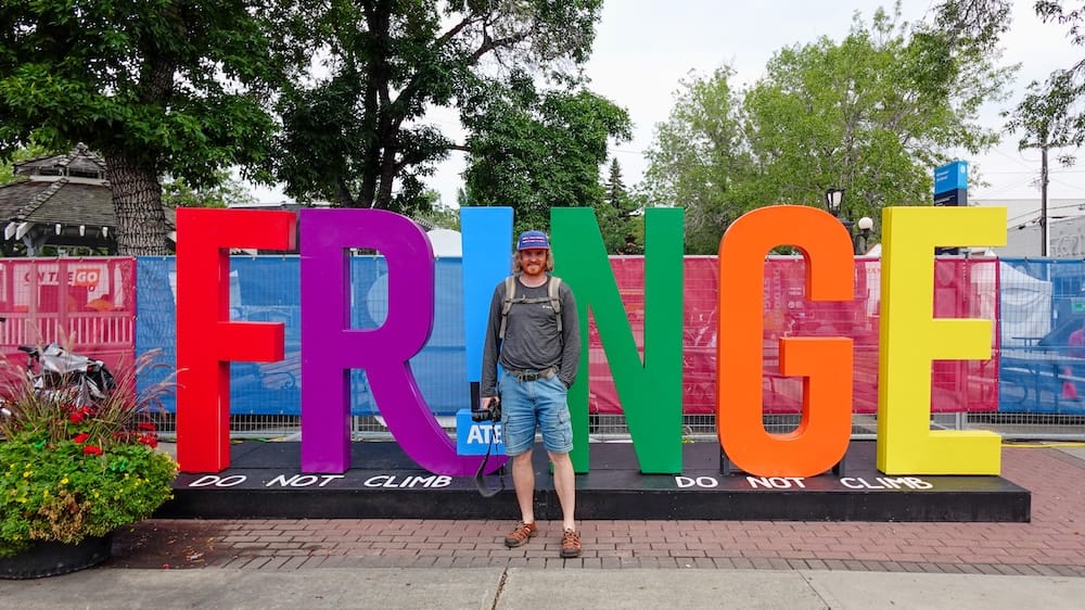 Samuel Jeffery en el Cartel del Edmonton International Fringe Festival, Old Strathcona, Edmonton, Alberta, Canadá Samuel Jeffery posa frente al gran cartel de letras coloridas que dice FRINGE, en el Edmonton International Fringe Theatre Festival, en Old Strathcona, Edmonton, Alberta, Canadá, con la cámara en la mano.