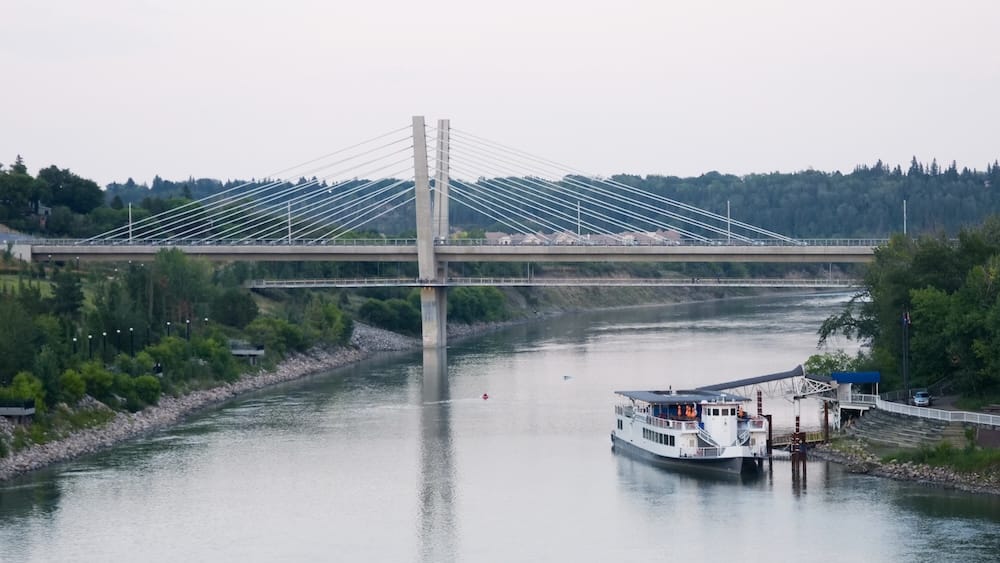 Riverboat de Edmonton sobre el río North Saskatchewan en Edmonton, Alberta, Canadá Riverboat de Edmonton atracado sobre el río North Saskatchewan en Edmonton, Alberta, Canadá, con un puente atirantado cruzando el agua y el verde River Valley bordeando ambas orillas.