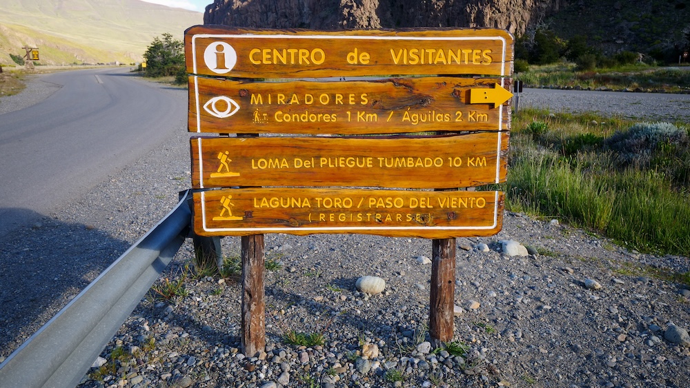 El Chaltén’s Centro de Visitantes trailhead sign pointing to Mirador de los Cóndores and Mirador de las Águilas, marking the start of the popular viewpoint hikes in Los Glaciares National Park, Patagonia.