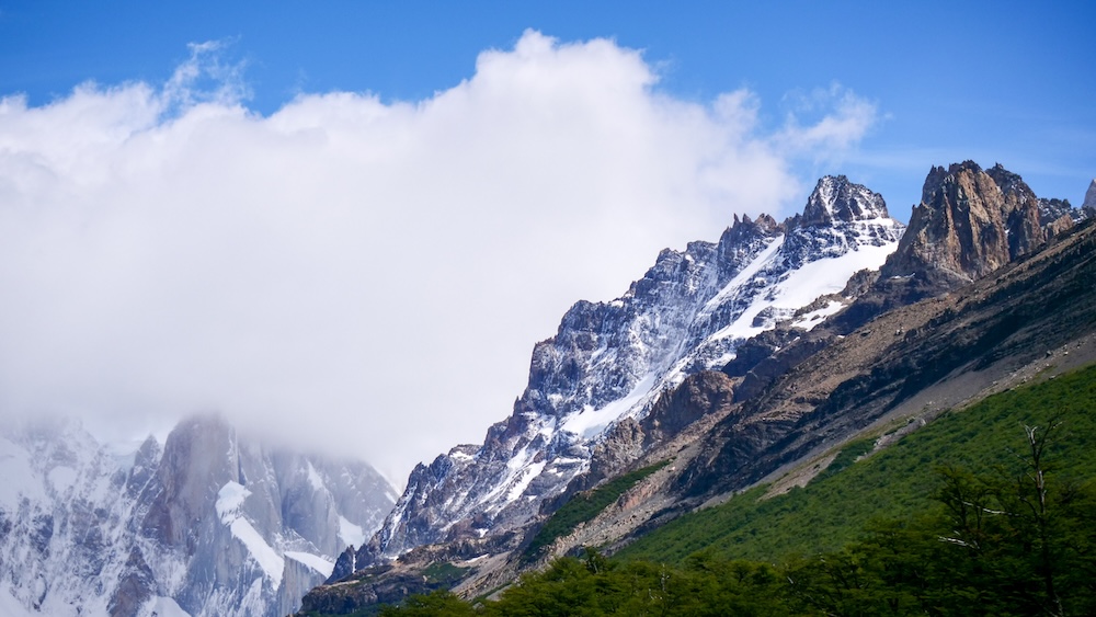 Clouds covering Cerro Torre peaks above the Laguna Torre valley in El Chaltén Patagonia El Chaltén Patagonia Cerro Torre mountain peaks partly hidden by clouds above the Laguna Torre valley in Los Glaciares National Park, illustrating the fast-changing Patagonian weather hikers face on popular trekking routes.