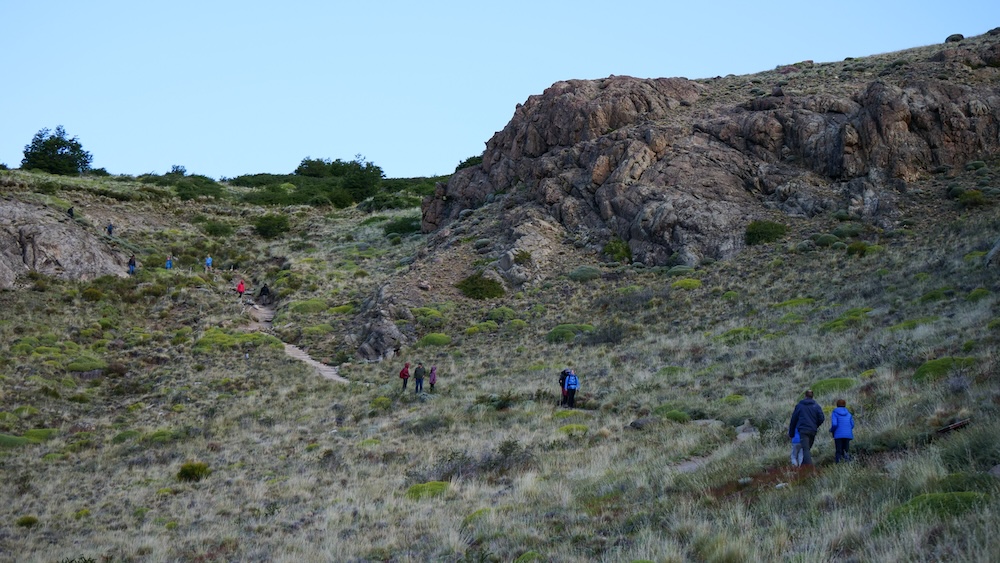 Hiking Mirador de los Cóndores in El Chaltén El Chaltén, Patagonia, Argentina hillside trail with hikers ascending the Mirador de los Cóndores path, a short but steep viewpoint hike offering sweeping valley and mountain views just outside town