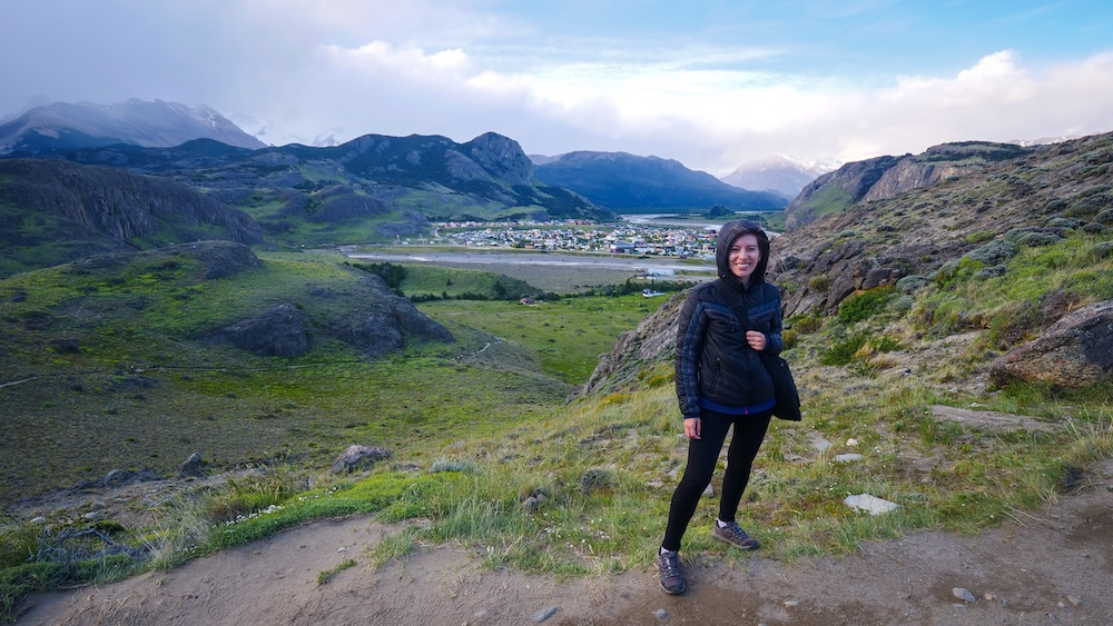 Mirador de los Cóndores viewpoint overlooking El Chaltén Patagonia after the short scenic hike above town El Chaltén Patagonia town view from Mirador de los Cóndores with Audrey Bergner standing along the scenic hillside trail overlooking the small mountain village and surrounding valleys after completing the short panoramic viewpoint hike.