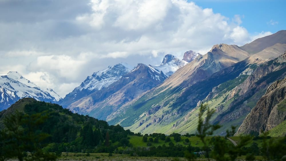 El Chaltén, Patagonia, Argentina landscape with dramatic mountains and shifting cloud cover, showing how weather can change suddenly as clouds roll across peaks and sunlight breaks through the valleys, highlighting the region’s famously unpredictable conditions.