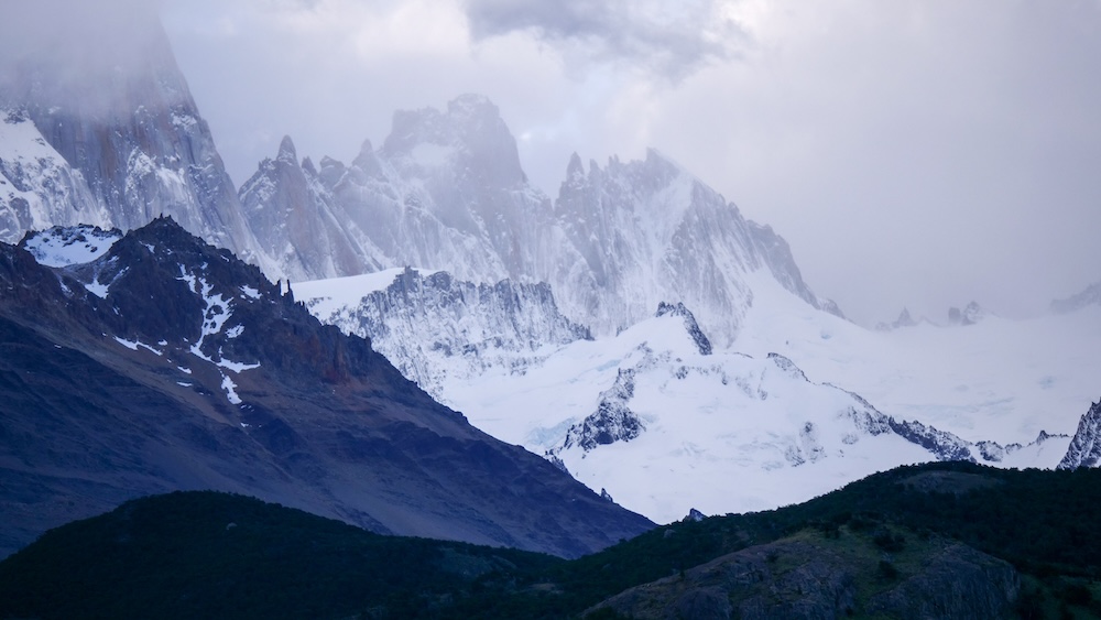 El Chaltén, Patagonia, Argentina snow-covered peaks under thick clouds and mist, showing moody mountain weather and sudden conditions shifts that can increase hiking difficulty on Patagonian trails