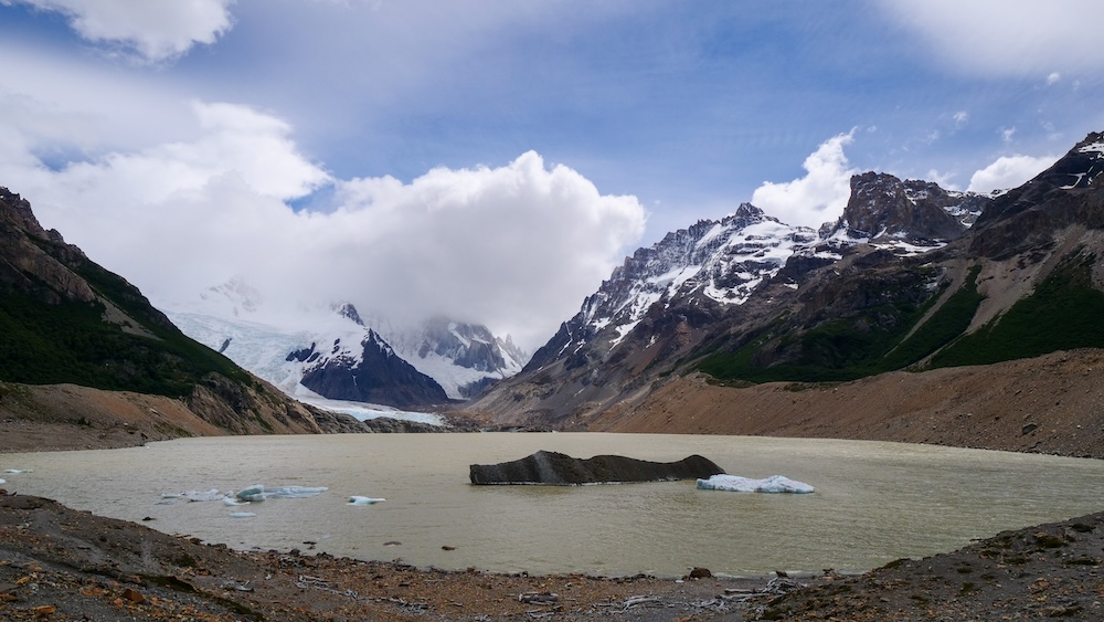El Chaltén Patagonia Laguna Torre glacier lagoon with cloudy Cerro Torre views El Chaltén Patagonia Laguna Torre glacial lagoon with floating icebergs and cloudy views of Cerro Torre and surrounding peaks in Los Glaciares National Park, showing the café-au-lait colored water created by glacial flour.