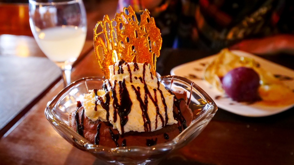 El Chaltén, Patagonia — a gourmet chocolate dessert at Senderos topped with whipped cream, chocolate drizzle, and a caramel sugar shard, the perfect sweet reward after a long day of hiking in Argentina’s trekking capital.