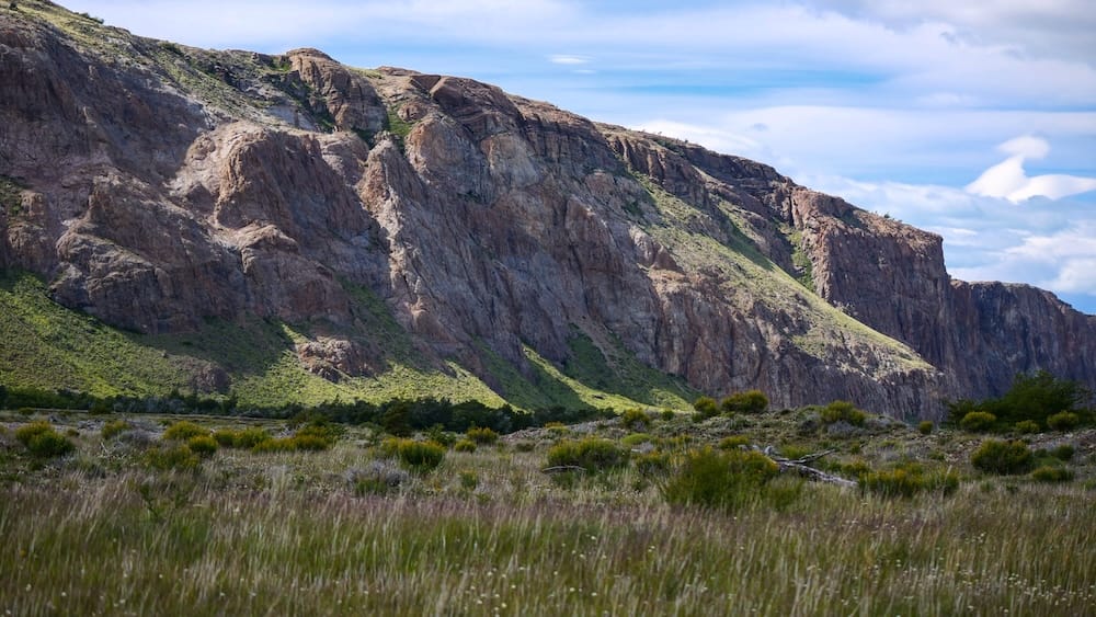 El Chaltén Patagonia rugged cliffs and windswept grasslands inside Los Glaciares National Park, showing the dramatic Patagonian terrain surrounding the hiking trails leading toward Mount Fitz Roy and Laguna Torre.