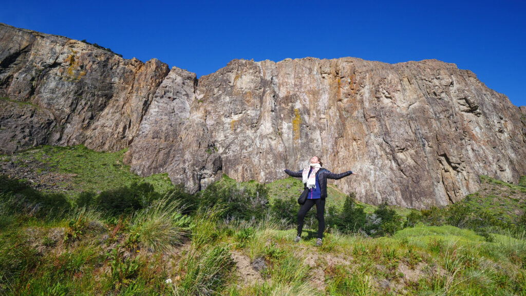 El Chaltén Patagonia mountain cliffs towering above town as Audrey Bergner enjoys dramatic views and fresh air without hiking the famous Fitz Roy trails in Los Glaciares National Park, proving the scenery can be enjoyed right from the village.