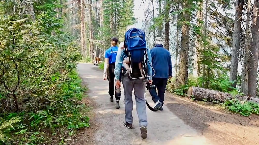 Samuel Jeffery hiking the Emerald Lake lakeshore trail in Yoho National Park, British Columbia, Canada Samuel Jeffery walks along the Emerald Lake lakeshore trail in Yoho National Park, British Columbia, Canada, carrying a child backpack through dense evergreen forest beside the lake.