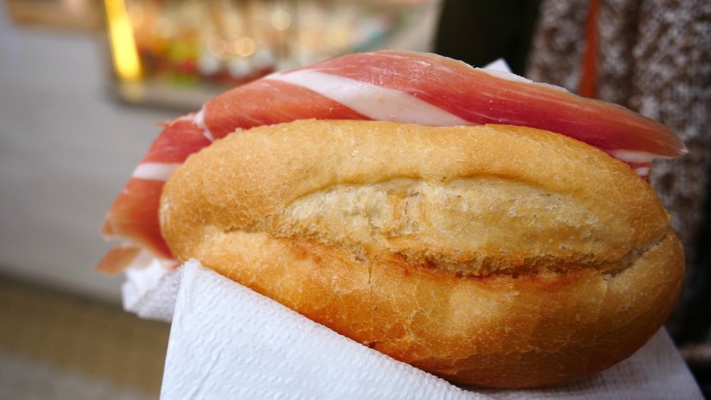 Enjoying street food jamon sandwich in Valencia, Spain 