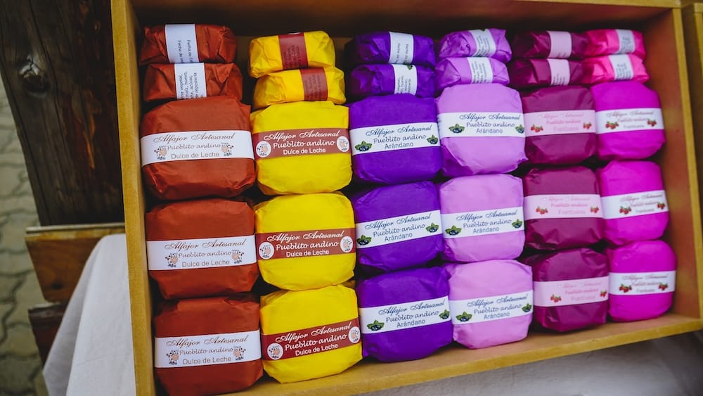 Artisanal alfajores in Esquel wrapped in colorful packaging with flavors like dulce de leche and local berries such as arándano, showcasing Patagonia’s regional twist on Argentina’s classic sandwich cookie dessert
