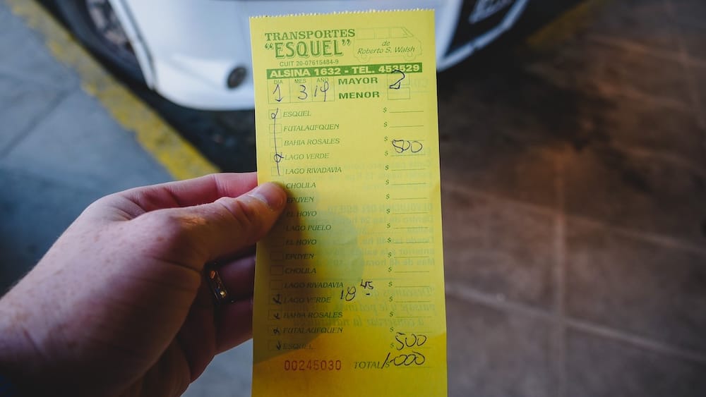 Pasaje micro Parque Nacional Los Alerces Esquel, Samuel Jeffery con boleto mostrando el riesgo de quedarse sin transporte en Patagonia