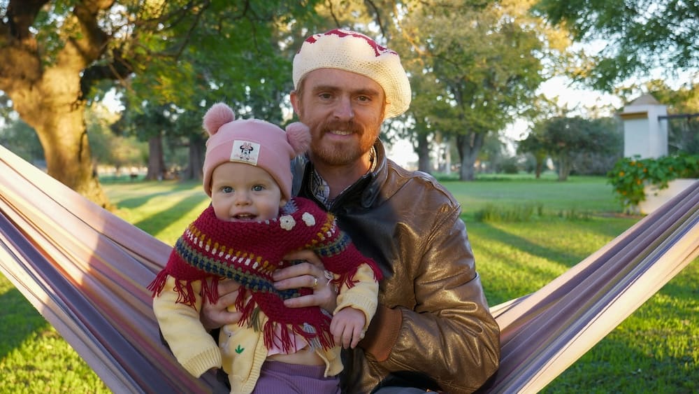 Estancia La Tomasa in Argentina with Samuel Jeffery holding Aurelia Jeffery on a hammock in a green countryside garden, adding family travel, rural estancia life, and lived fieldwork context to Project 23.