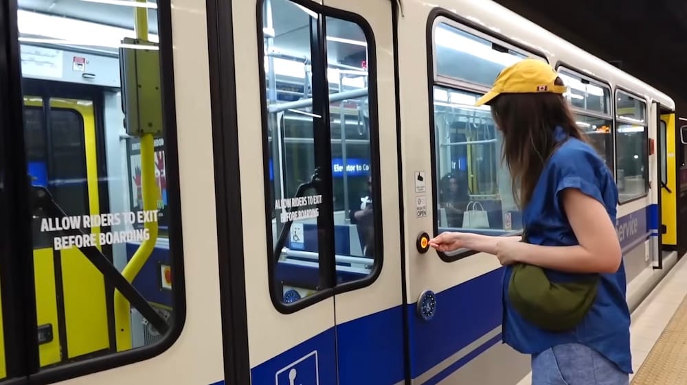 Audrey Bergner Boarding the LRT, Edmonton Transit Service, Edmonton, Alberta, Canada Audrey Bergner presses the door-open button while boarding an ETS LRT train in Edmonton, Alberta, Canada, with "allow riders to exit before boarding" signage visible on the train doors.