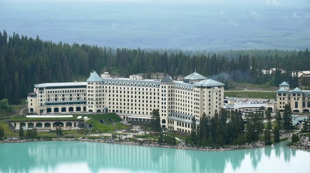 Fairmont Chateau Lake Louise in Banff National Park, Alberta, Canada beside turquoise Lake Louise Fairmont Chateau Lake Louise stands beside turquoise Lake Louise in Banff National Park, Alberta, Canada, with forest surrounding the large lakeside hotel and visitors visible along the shoreline.