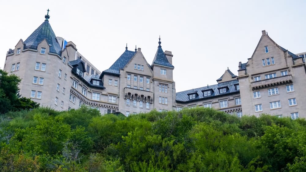 Fachada del Fairmont Hotel Macdonald, Edmonton, Alberta, Canadá La fachada de piedra con torreones y el techo empinado de cobre del Fairmont Hotel Macdonald se alzan sobre una ladera verde del valle del río, en el centro de Edmonton, Alberta, Canadá.