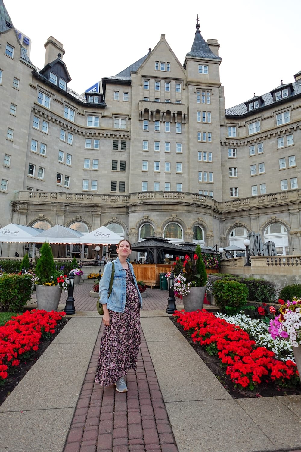 Audrey Bergner at Fairmont Hotel Macdonald in Edmonton, Alberta, Canada during our slower overnight stay Audrey Bergner stands in front of Fairmont Hotel Macdonald in Edmonton, Alberta, Canada, with the historic château-style exterior, flower beds and hotel terrace visible during our slower overnight stay.