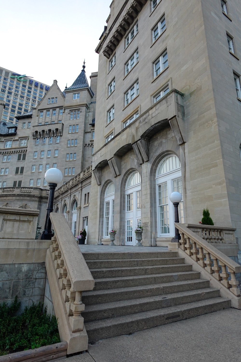 Fairmont Hotel Macdonald exterior architecture The exterior of the Fairmont Hotel Macdonald in Edmonton showcases grand stone architecture, arched windows, decorative balustrades and elegant staircases leading to a terrace, highlighting the château-style design and historic character of this iconic Canadian railway hotel.