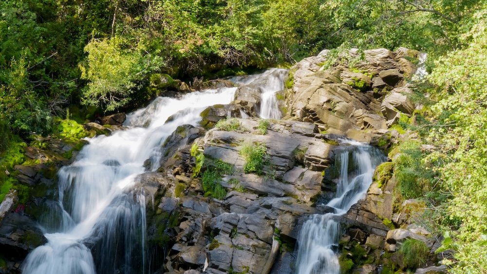 Fairy Creek Falls in Fernie, British Columbia cascading over layered rock formations surrounded by lush forest, showcasing one of the area’s most popular and accessible waterfall hikes, often included in a two-day Fernie itinerary for first-time visitors seeking scenic nature experiences.