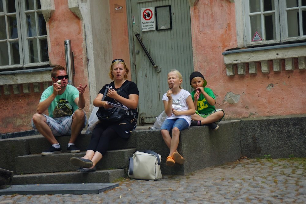 Family enjoying a relaxing day eating ice cream while visiting Suomenlinna