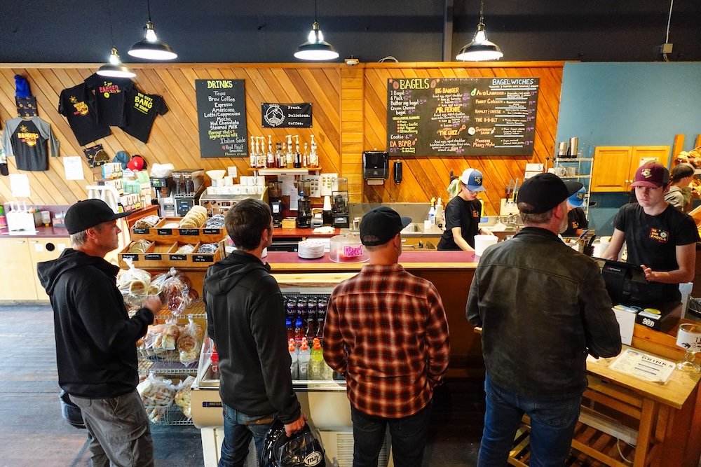 Morning line at Big Bang Bagels in Fernie, BC Fernie, British Columbia, customers lined up inside Big Bang Bagels waiting to order fresh bagel sandwiches, capturing the busy morning rush at Fernie’s most popular breakfast spot and a must-stop for essential hiking and sightseeing fuel.
