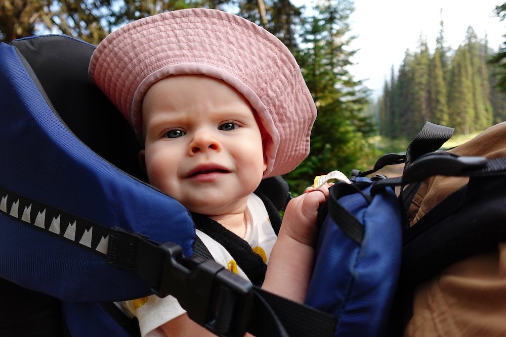 Family-friendly Fernie adventure with baby Aurelia Baby Aurelia relaxing in a hiking backpack while exploring Fernie, British Columbia, highlighting how family-friendly stops like Fernie Brewing Company welcome parents traveling with young children after easy hikes and outdoor adventures in the Canadian Rockies.