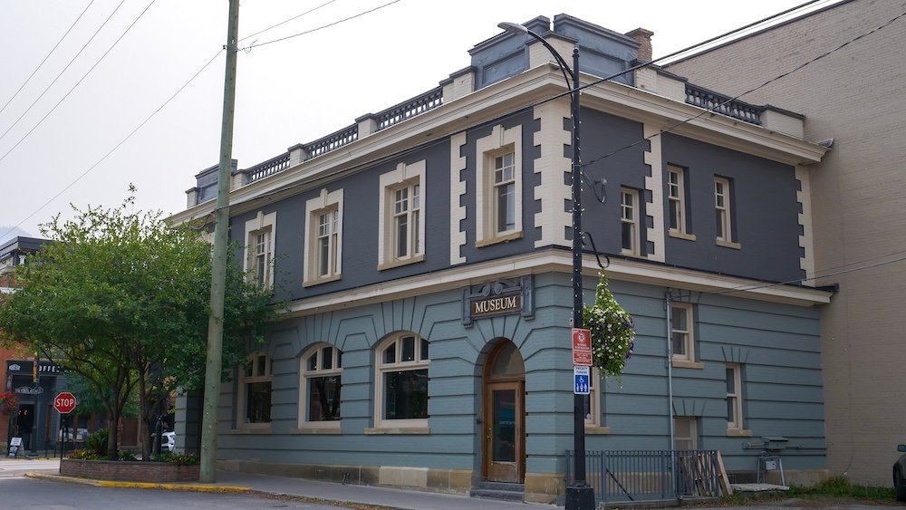 Fernie, BC Museum exterior historic downtown building Fernie Museum in Fernie, BC photographed from across the street, showcasing the historic blue-and-cream heritage building with classic architectural details, downtown surroundings, and mountain-town atmosphere that make it a key cultural stop during a Fernie visit.
